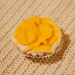 Mango tart with a white base on a textured beige surface