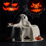 Halloween-themed cake with ghost decoration and jack-o'-lanterns in the background
