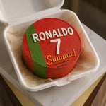 Red cake with 'RONALDO 7 Siuuu!' text in a white container