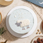 Decorative cake with sheep design on a textured surface
