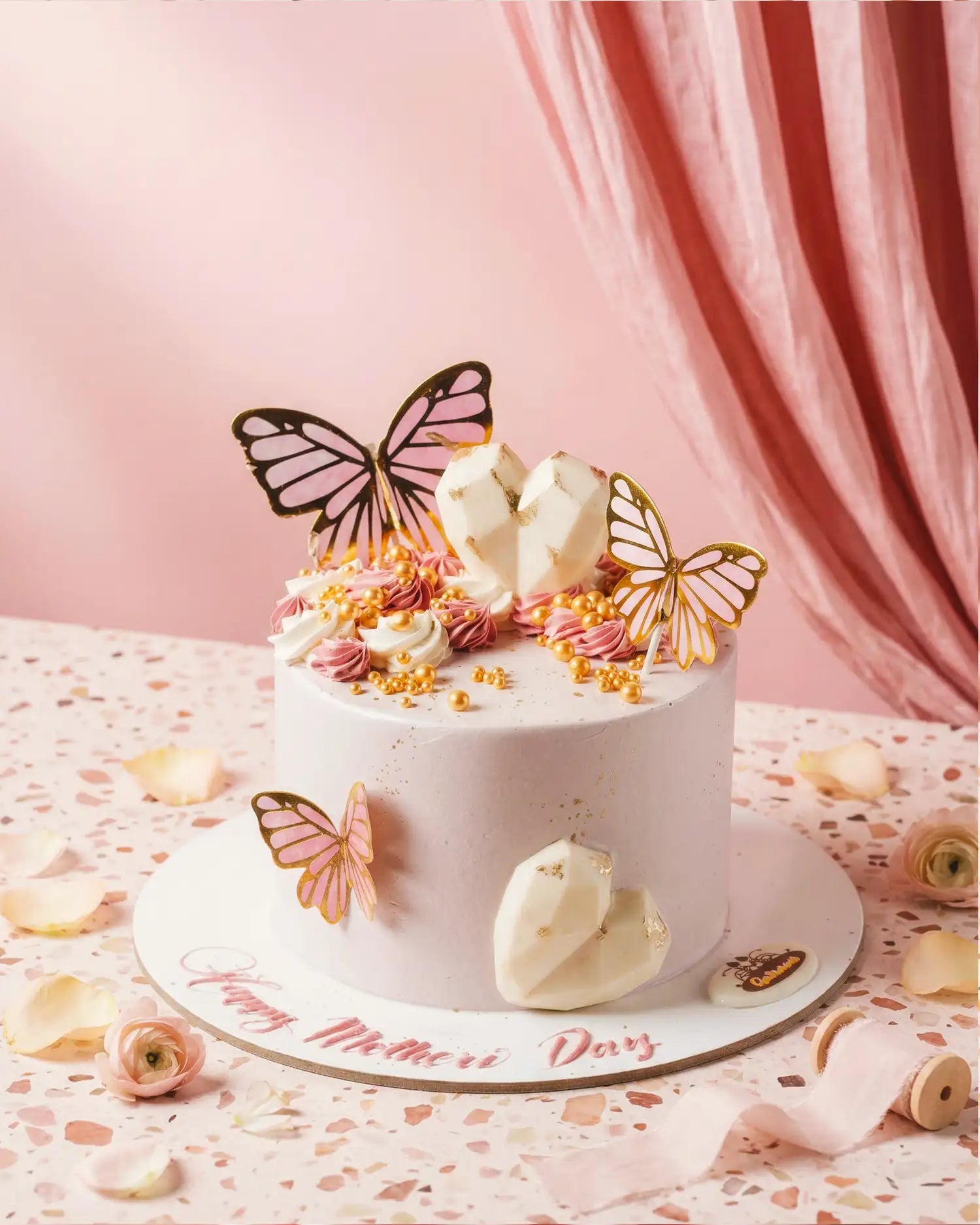 Decorative cake with butterfly toppers on a pink background