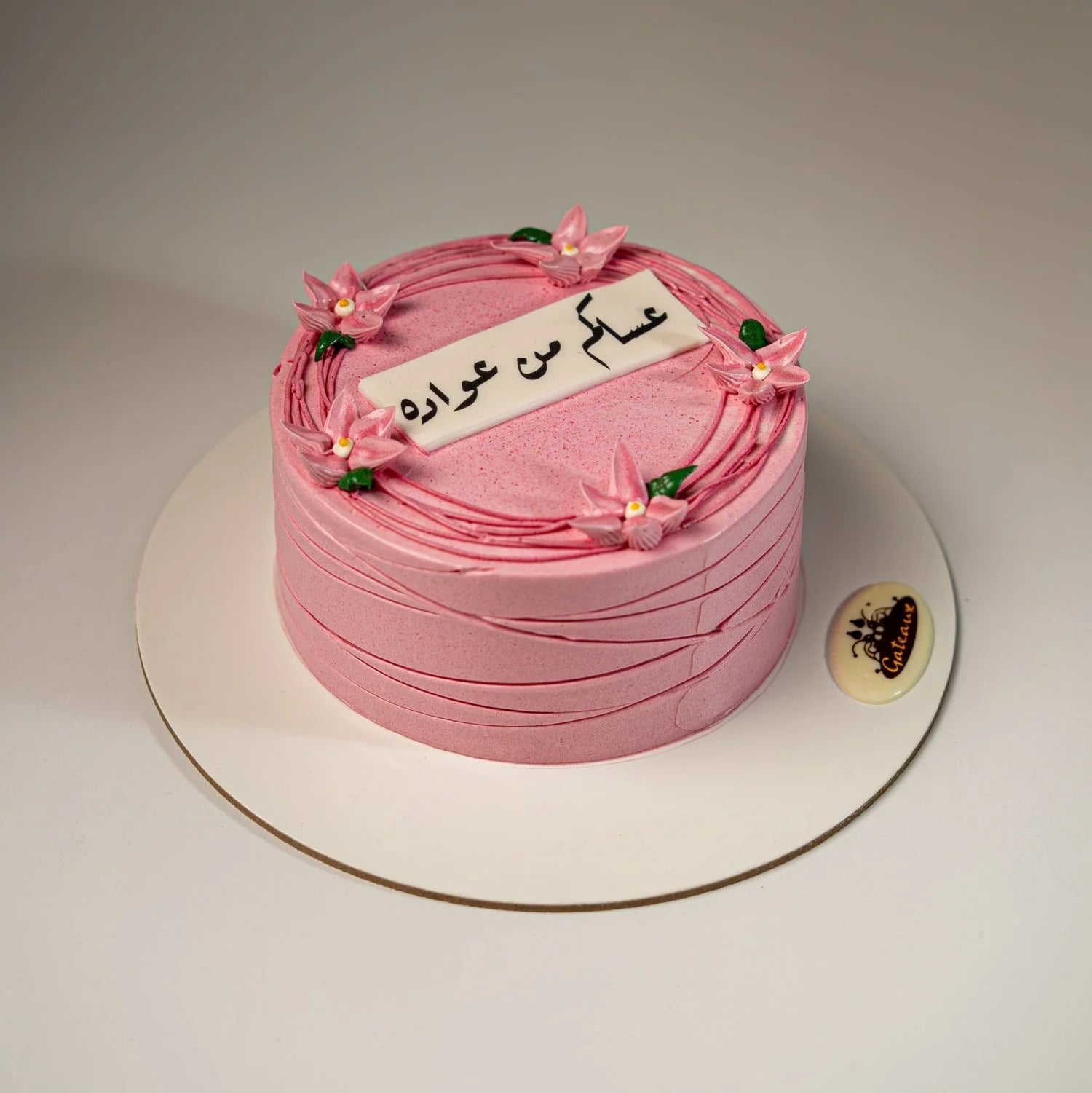 Pink cake with floral decorations on a white background