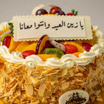 Decorative cake with fruits and a message in Arabic, featuring the brand 'Gâteaux'.