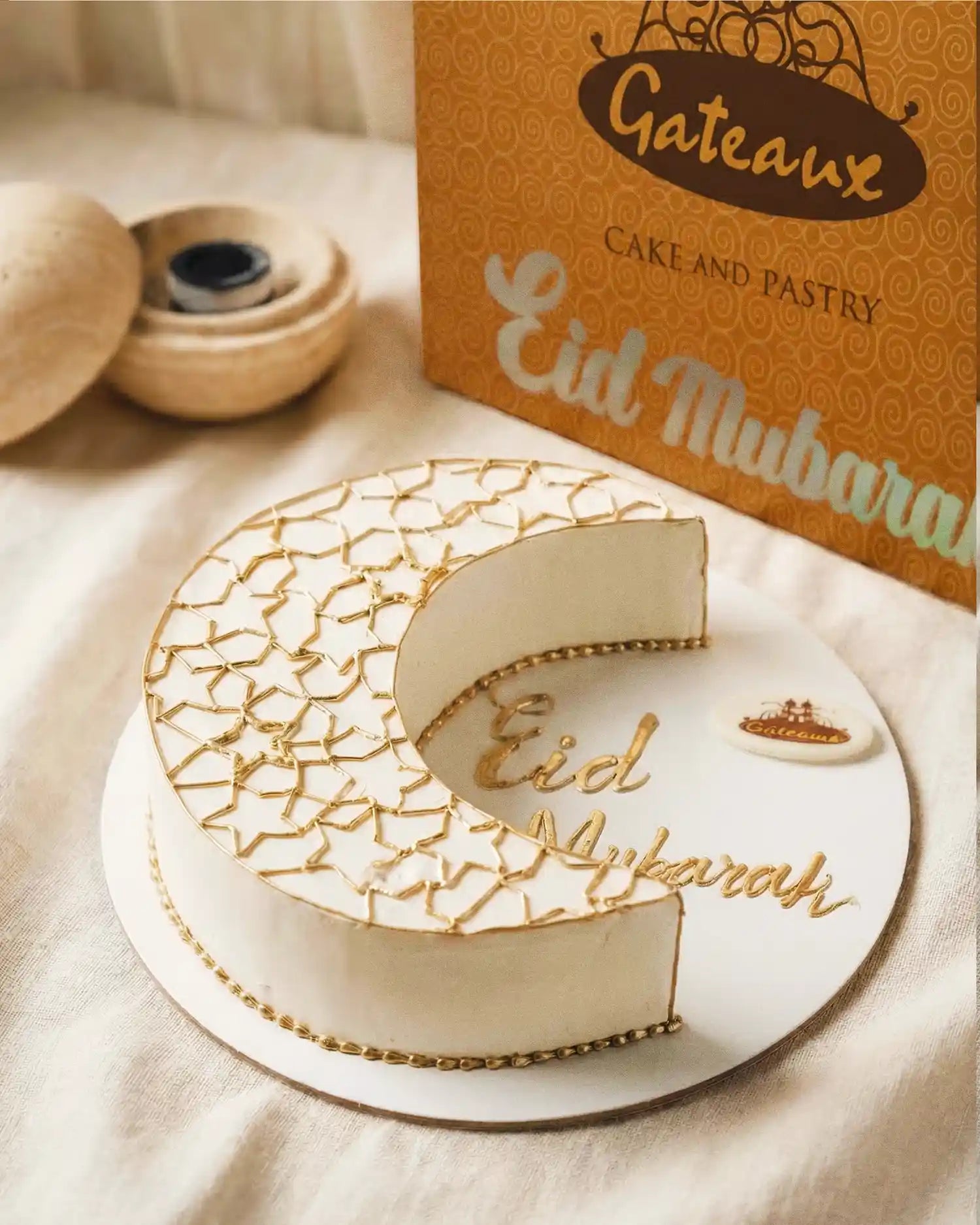 Decorative cake with 'Eid Mubarak' text and a box labeled 'Gateau' in the background.