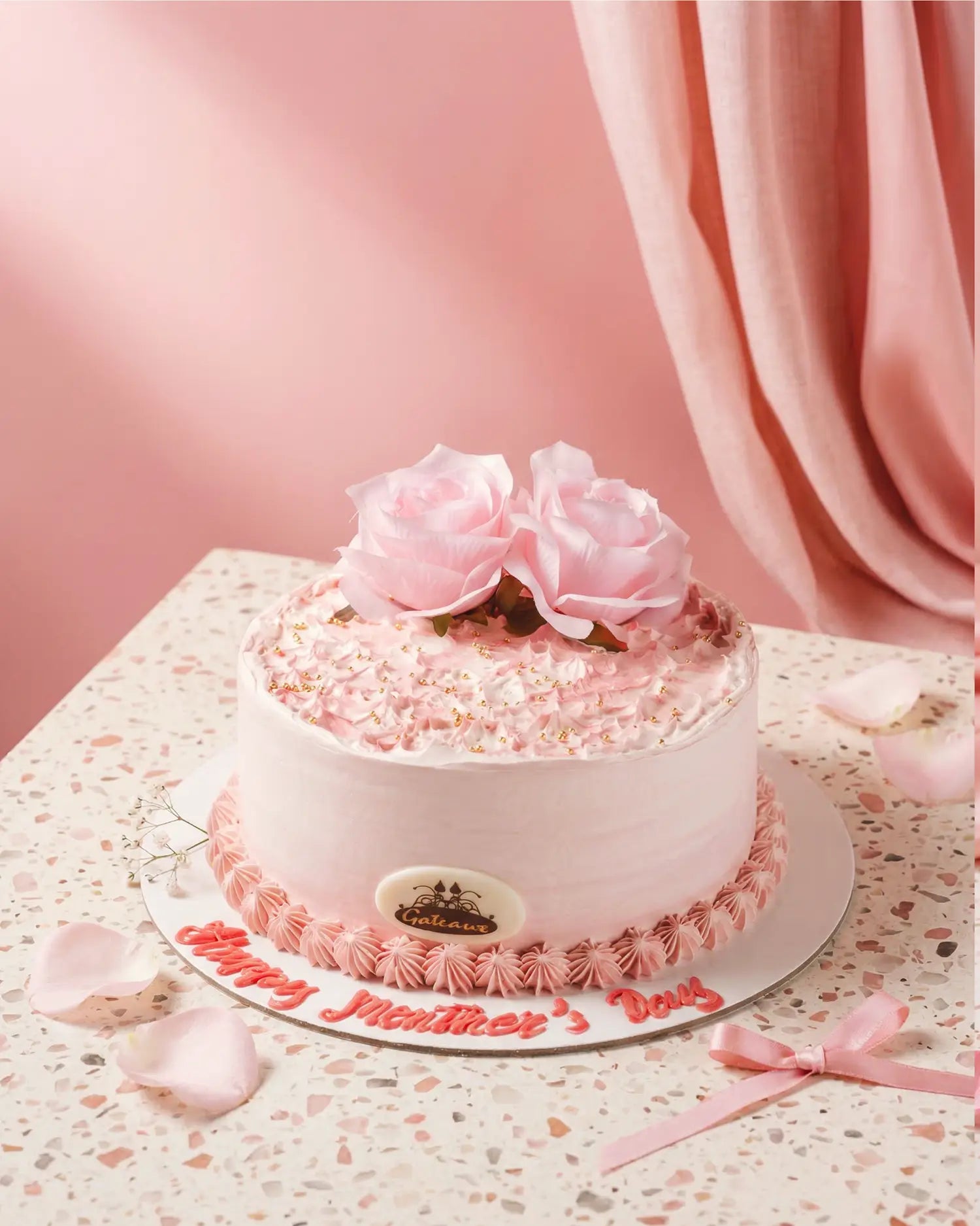 Pink birthday cake with roses on a decorative plate against a pink background