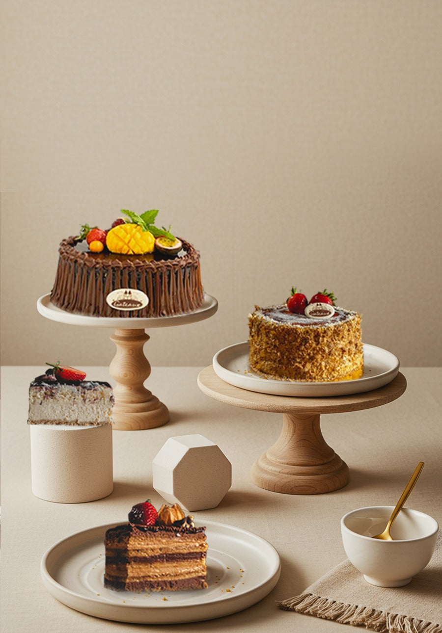 Assorted cakes on stands with a neutral background