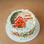 Christmas-themed cake with gingerbread house and 'Merry Christmas' text on a brown background
