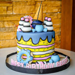 Colorful birthday cake with fondant decorations on a wooden background