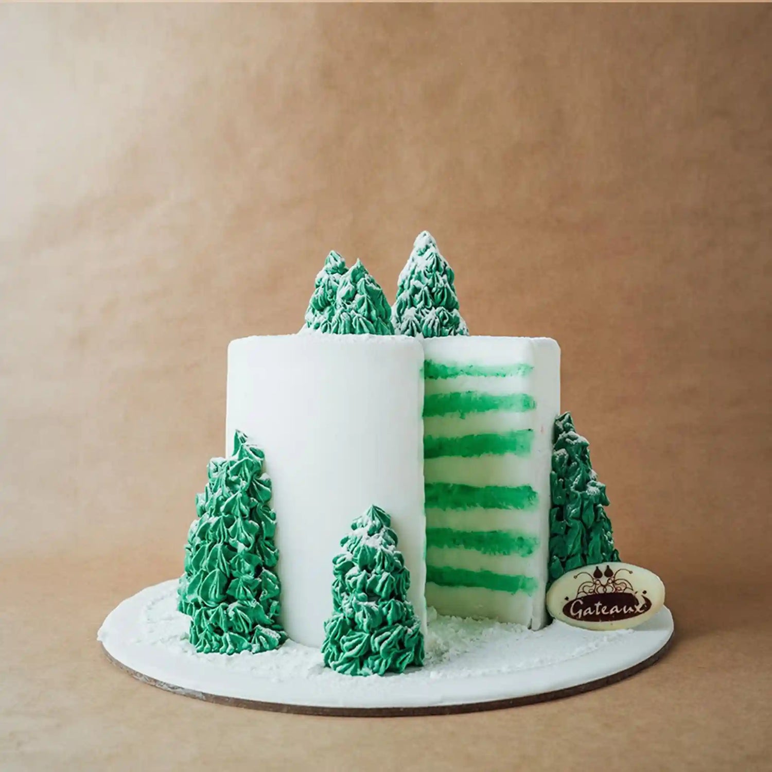Decorative cake with green trees and a white base on a brown background