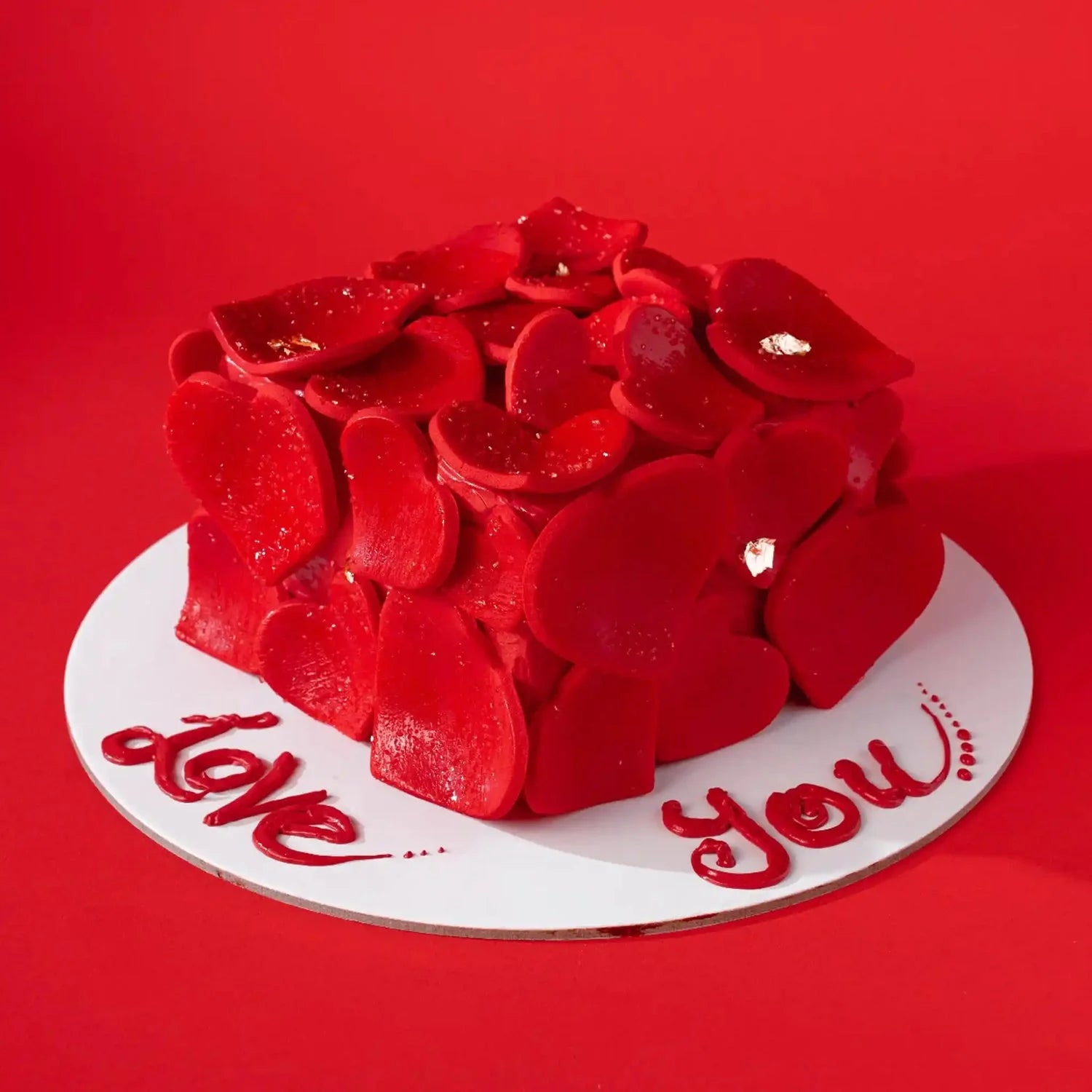 Red heart-shaped cake with 'I love you' text on a red background