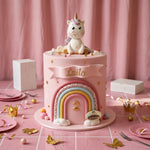 Pink fondant unicorn cake with pastel rainbow and personalized name banner