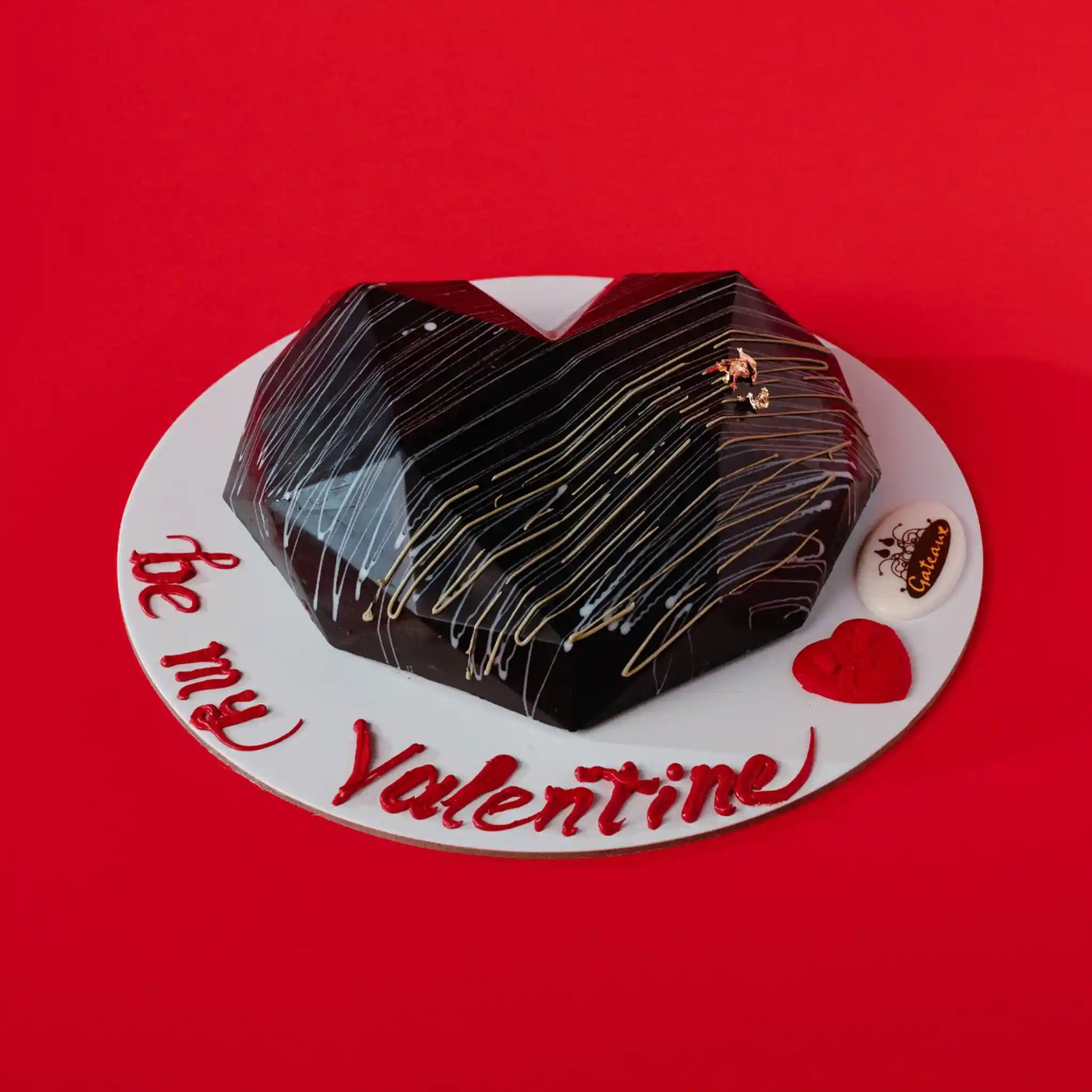 Heart-shaped chocolate cake on a red background with 'be my Valentine' text