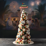 Decorative cake with UAE-themed decorations on a table with a blurred background of people and lights.