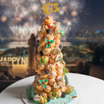 Decorative cake with 'Happy New Year' topper in front of fireworks