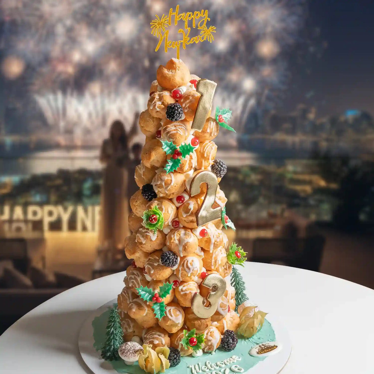 Decorative cake with 'Happy New Year' topper in front of fireworks