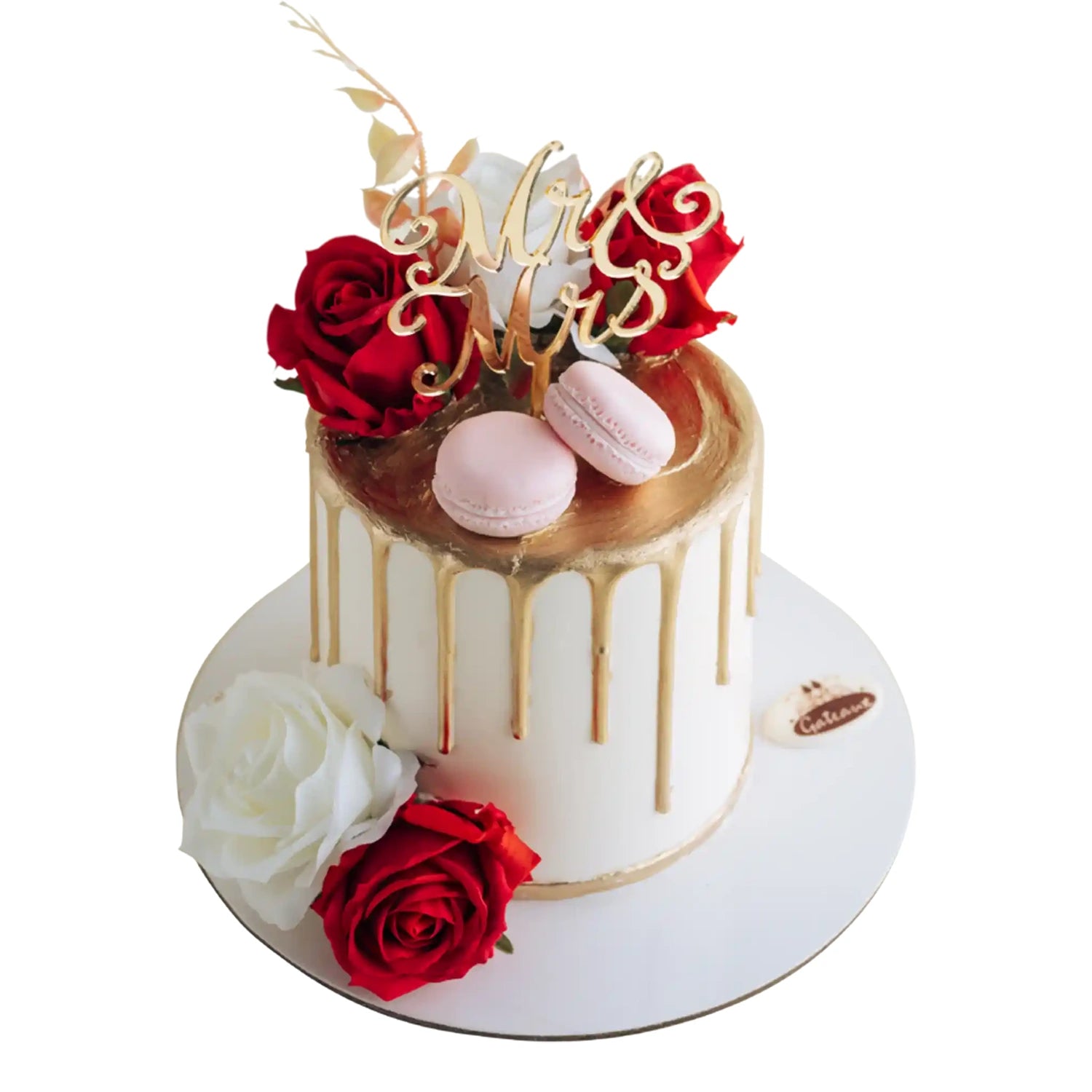 Decorative cake with gold drizzle, red and white roses, and 'Mrs.' topper on a white background