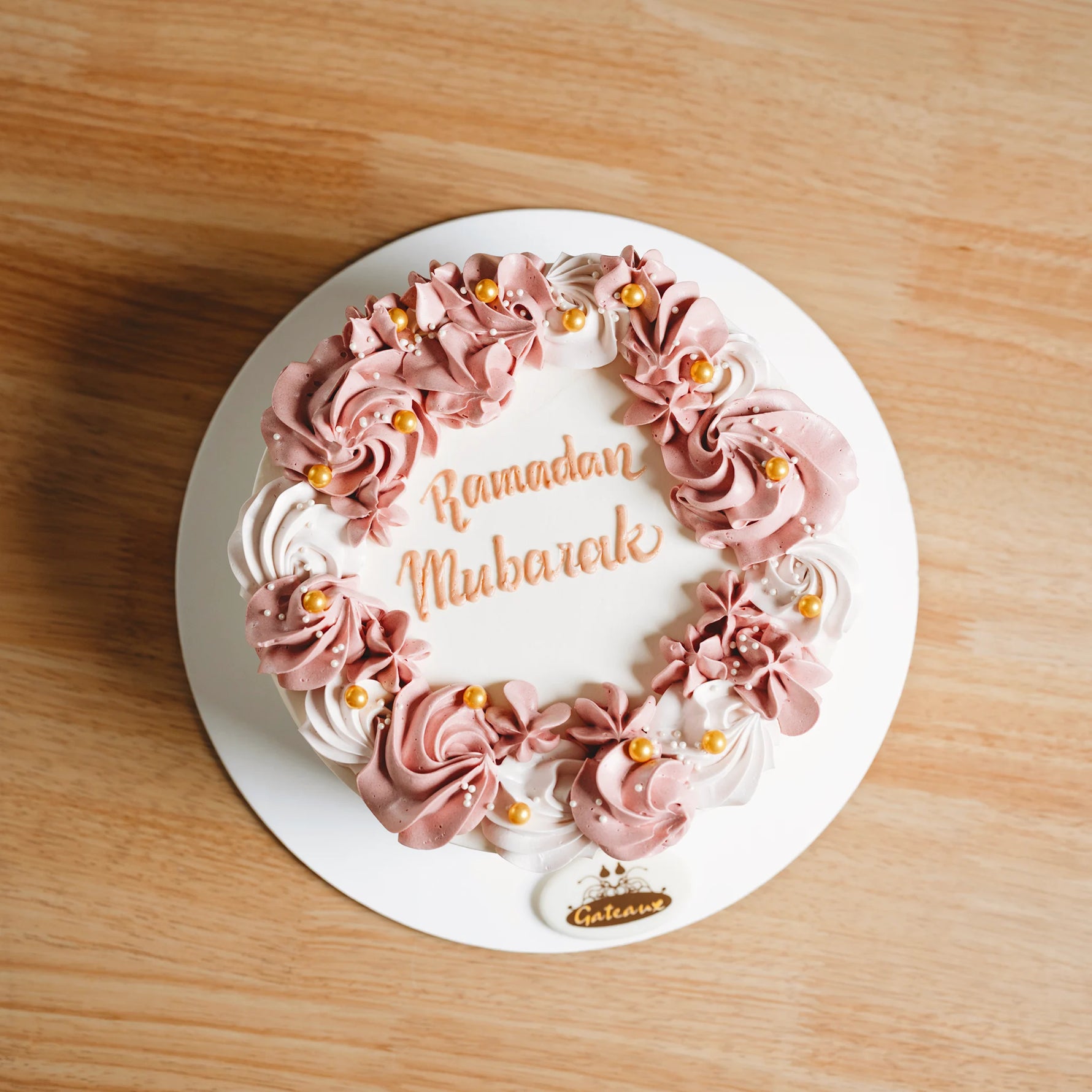 Decorative cake with 'Ramadan Mubarak' text on a wooden surface