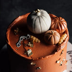 Chocolate cake with pumpkin decorations on a dark background