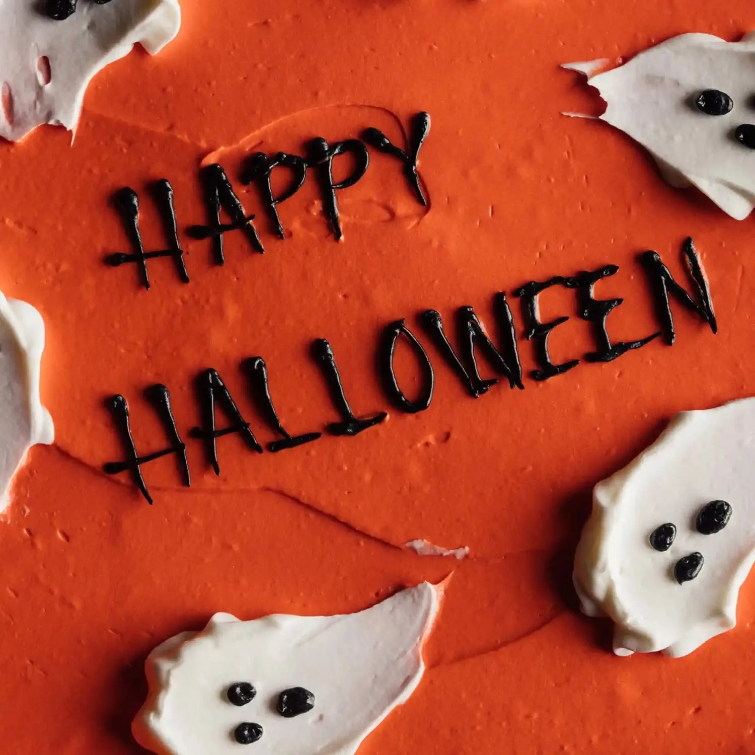 Halloween-themed cookie with 'Happy Halloween' text on an orange background