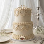 Decorative two-tier cake with lace details on a white background