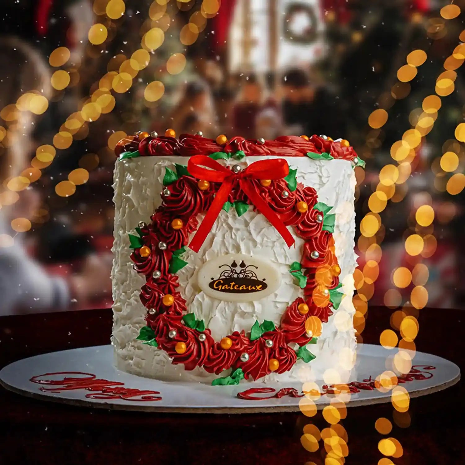 Decorative cake with red and green icing, featuring a bow, on a blurred festive background.