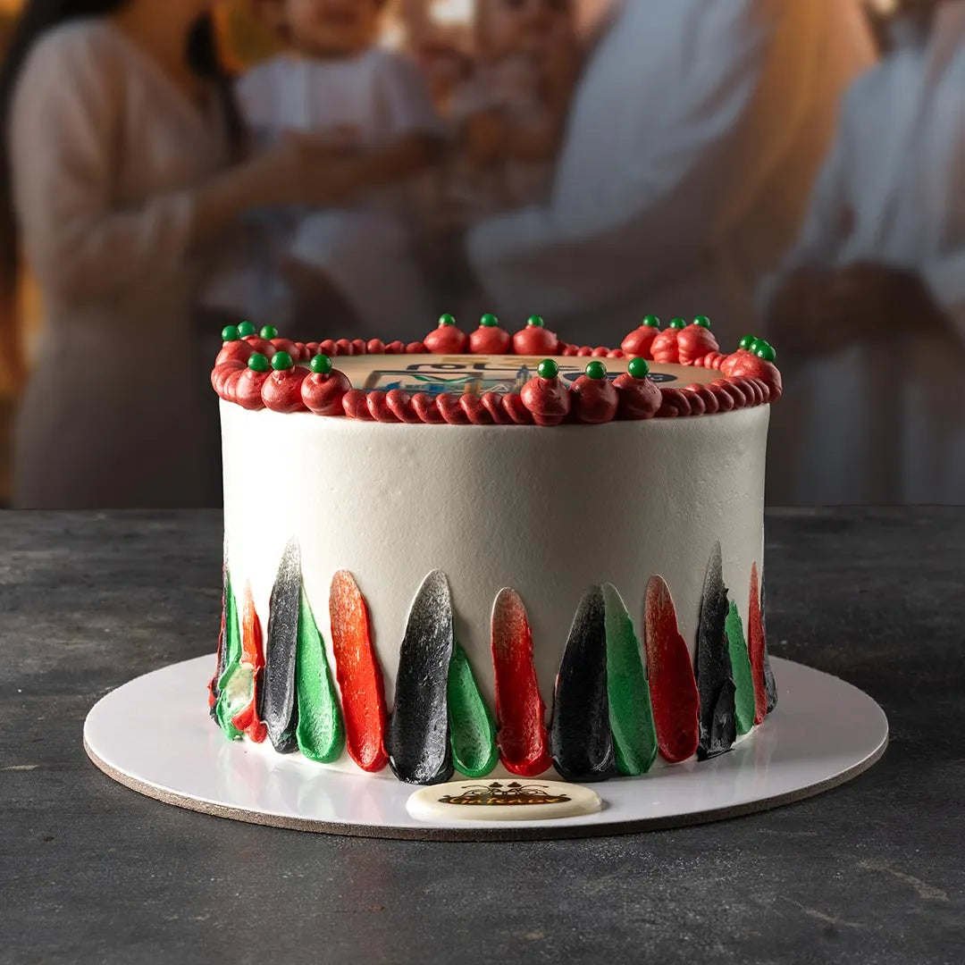Decorative cake with red, green, and black icing on a dark surface