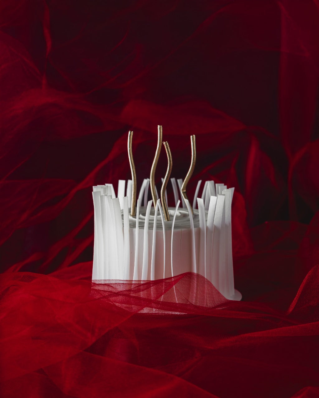 A Valentine's Day cake with white ribbons on it, presented on a red background.