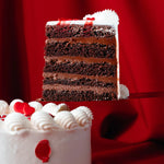 Slice of layered chocolate cake with white frosting on a red background